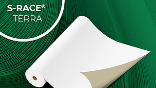 Große Papierrolle auf einem grünen Hintergrund, oben links in einem Kreis steht S-RACE Terra