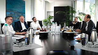 Meeting mit mehreren Geschäftsleuten an einem Tisch